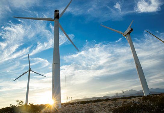 Sun setting on wind turbines on a wind farm