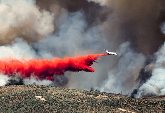 a plane attempting to extinguish a fire below