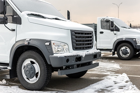 New middle size trucks at dealership parked outdoors in winter. 