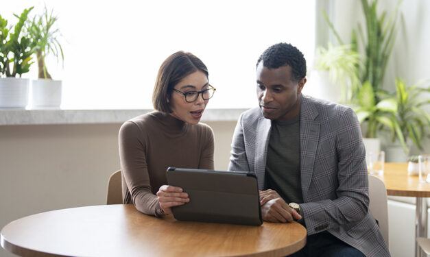 Agent working on a tablet while talking to a client.